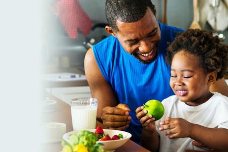 Dad and daughter eating fruit as part of healthy living
